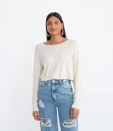 Blusa cropped color crema de tejido de punto, con cuello redondo, manga larga y sisa desplazada.