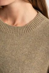 Sweater de punto color tostado con calce oversize, cuello redondo y mangas largas anchas. Presenta terminaciones acanaladas en cuello, puños y ruedo.
