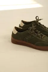 Zapatilla de diseño moderno, con detalle trasero en tono beige y suela chunky.