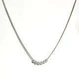 Collar tipo gargantilla con cadena fina bañada en oro 18k y seis perlas blancas dispuestas en forma de arco en el centro.