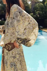 Blusa estampada con hilo metalizado, cuello redondo con volante, escote pico y manga larga abullonada.