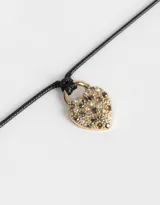 Gargantilla con cordón negro y dije de corazón dorado cubierto de strass multicolor.