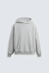 Sudadera gris con capucha, corte relaxed fit, confeccionada en tejido de algodón con interior de rizo, manga larga, bolsillo tipo canguro y terminaciones en rib.