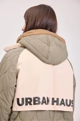 Campera acolchada reversible color verde militar, con capucha y cierre frontal con botones a presión.