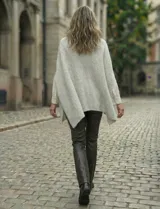 Poncho tejido de punto grueso, color mostaza/mostaza oscuro, con cuello redondo y caída amplia.