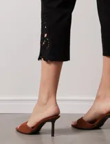 Pantalón capri negro de gabardina elastizada con pretina ancha elastizada y ruedo con aplique de crochet.