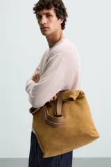 Jersey color verde claro de punto tejido en hilatura ligera de lino, corte relaxed fit, cuello redondo y manga larga con terminaciones en rib.