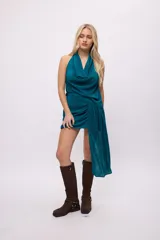 Falda corta color rosa metalizado, con frunces y drapeado lateral que se extiende hasta el tobillo.