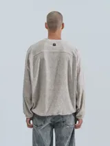 Sweater de tejido jaspeado color beige claro, con cuello redondo, mangas ranglán y elástico ajustable en el bajo.