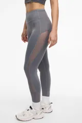 Calza deportiva larga negra con cintura alta, detalles de transparencias laterales en tul y bolsillos laterales.