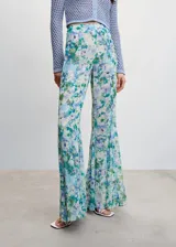 Pantalón acampanado de tejido fluido con estampado floral en tonos azules y verdes, tiro alto y cierre lateral de cremallera.