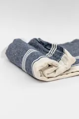 Lona de playa rectangular con diseño estampado a rayas rojas y blancas.