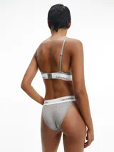Conjunto Calvin Klein Modern Cotton color gris melange, compuesto por un bralette triangular sin relleno y una tanga con cintura elástica con logo de la marca.