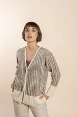 Cardigan tejido con efecto fantasia color crema. Una prenda de silueta amplia y cómoda. Tejido en 100% lana fina sin teñir.