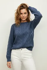 Sweater de punto acrílico color azul, con diseño de punto trenzado en el frente y mangas, cuello redondo y calce holgado.