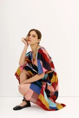 Vestido midi de gasa estampada con diseño geométrico multicolor, mangas cortas y elástico en la cintura. Tiene tajo frontal y forro en la falda.