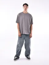 Remera gris de corte oversized, cuello redondo y mangas cortas. 
