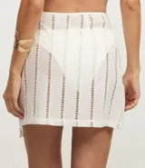 Minifalda de playa color crudo, con detalles de laise calado y ajuste lateral con lazos terminados en caracoles.