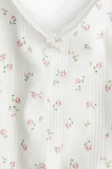 Top blanco de punto pointelle con estampado floral en tonos rosados, escote en V y breteles finos regulables.