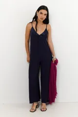 Mono de mujer color azul marino, con escote en V profundo y tirantes finos. Presenta un detalle de tela satinada en el escote.