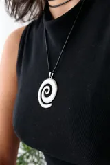 Collar con dije plateado en forma de espiral y cordón negro encerado.