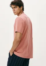 Camiseta blanca de algodón con cuello redondo y mangas cortas. Estampa rectangular con borde negro que contiene la frase "NATURAL ATMOSPHERE" en letras mayúsculas y una imagen de montañas y mar.