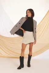 Blazer de color beige con diseño a cuadros, de corte clásico y botones frontales.