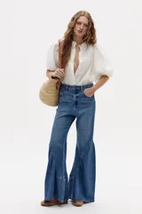 Pantalón de jean acampanado azul con diseño de paneles en la parte inferior.