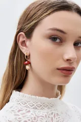 Aros de argolla dorada con dije colgante en forma de hongo de resina roja y blanca con incrustaciones de strass.