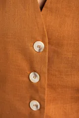 Chaleco negro con escote en V y cierre frontal con botones.