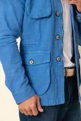 Cazadora blanca de lino con cuello camisero, cierre con botones, cuatro bolsillos frontales con solapa y corte entallado.