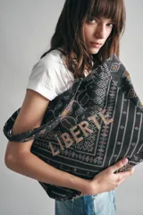 Bolso tipo tote bag negro con estampado geométrico multicolor y la palabra 'Liberté' bordada en dorado.