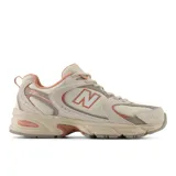 Championes urbanos New Balance modelo 530, color crema con detalles en beige y naranja, confeccionados en malla y cuero sintético, con logo "N" característico en los laterales y entresuela ABZORB.