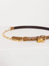 Cinturón marrón de cuero vacuno con cadena metálica dorada y aplique Groovy en el pasador.