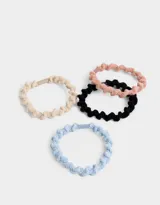 Set de cuatro gomitas de pelo elásticas con textura trenzada en colores celeste, beige, rosa y negro.