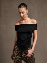 Top negro con escote off-shoulder y corte irregular en el ruedo.