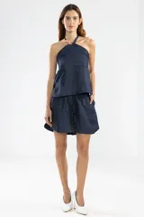 Top halter azul marino con escote halter que se ajusta mediante un cordón al cuello.