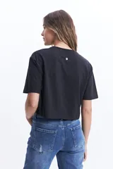 Remera corta color verde lima con estampado frontal de un corazón y la frase "love is a verb".