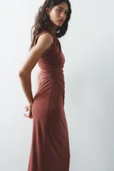 Vestido midi marrón de tejido de punto, con cuello redondo, sin mangas, drapeado en el lateral y abertura en la espalda.