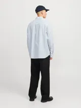 Camisa de manga larga a rayas verticales celestes y verdes sobre fondo blanco, con fit comfort y cuello clásico. Confeccionada en tejido dobby de algodón y lino, con cierre frontal con botones.