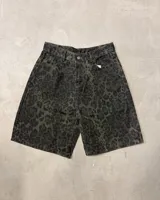 Bermuda de jean tiro alto, corte recto y largo hasta la rodilla, con estampado animal print de leopardo en tonos verde militar y negro.