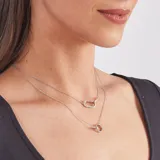 Conjunto de joyería de plata 925 que incluye aros tipo argolla con circonias, un collar de cadena fina con dije de eslabón alargado y otro dije de anillo, y una pulsera con dos anillos entrelazados.