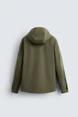 Parka verde militar de tejido técnico ligero resistente al viento, con cuello alto, capucha y manga larga con puños ajustables. Tiene bolsillos de plastrón con solapa en la cadera, bolsillo interior y bajo ajustable con elásticos. El cierre frontal es con cremallera oculta por solapa con botones a presión.