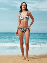 Conjunto de bikini azul oscuro con corpiño triangular con volados en los breteles y bombacha con volados en la cintura.