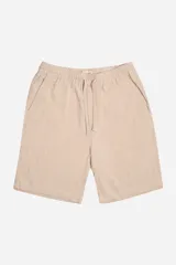 Bermuda de lino color beige, corte jogger con cintura elástica ajustable con cordón, bolsillos laterales y trasero.