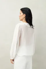 Camisa negra de tencel liviana con volados románticos y manga corta.