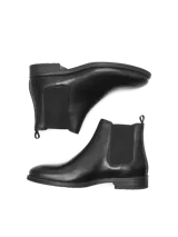 Botas Chelsea negras de cuero, con elásticos laterales y suela de goma.