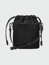 Bolso pequeño tipo cubo (bucket bag) de cuero negro, con cordón ajustable en la parte superior y solapa con broche a presión. Se lleva cruzado con una correa fina y ajustable.