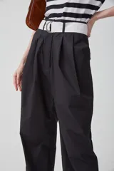 Pantalón de gabardina liviana de algodón color azul marino, de tiro alto con pinzas delanteras que generan volumen, bolsillos americanos y acceso frontal con cartera con cierre metálico.