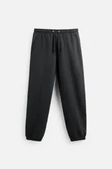 Pantalón de jogging negro, corte balloon fit, con cintura elástica ajustable con cordón, bolsillos laterales y trasero, costura frontal en las perneras y puños elásticos en los tobillos.